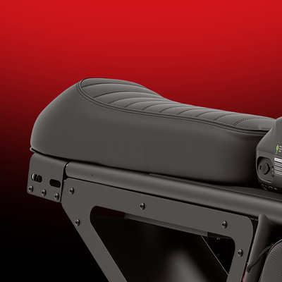 Close-up of the iScooter DX5 Max padded bench seat, featuring a contoured ergonomic design with stitched detailing. The image highlights the seat’s comfort-focused construction and sturdy frame support against a red gradient background.