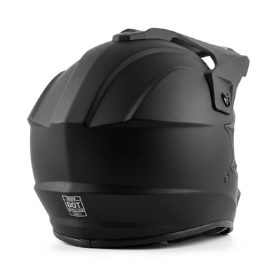 Rear-three-quarter view of a matte black full-face dirt bike helmet, featuring integrated top ventilation, a sun visor peak, and a prominent white DOT safety certification emblem printed at the bottom back center.