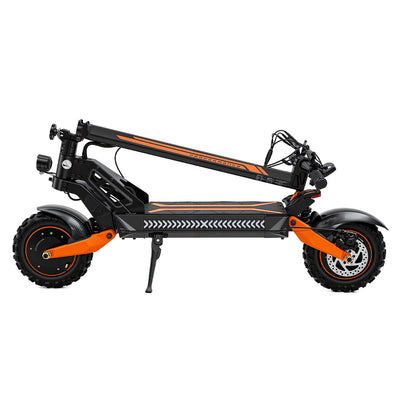 Side view of a foldable black electric scooter with orange accents, shown in its folded position with off-road tires, front suspension, disc brakes, and kickstand against a white background.